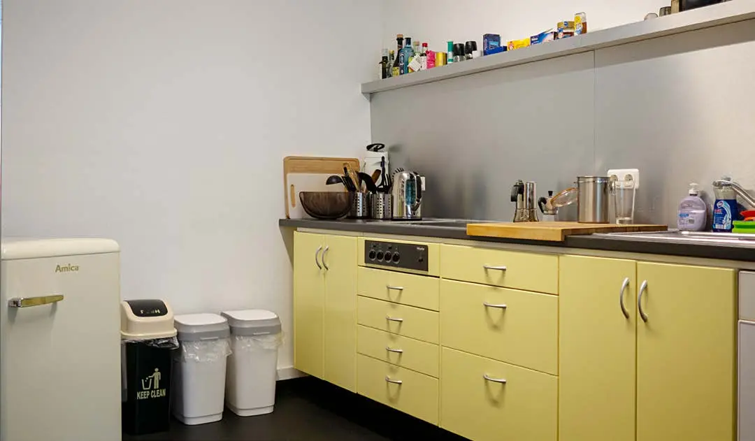 Küche mit Spülmaschine, Kühlschrank und Inventar